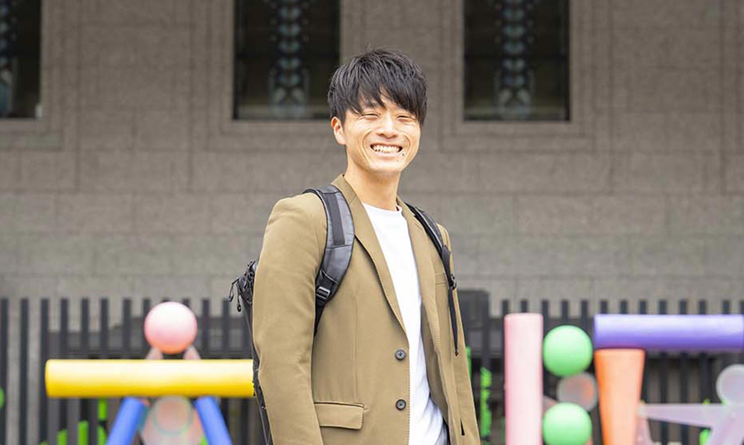 森下 大樹 大阪市役所の大阪フォトモニュメントの前で笑顔で立っている