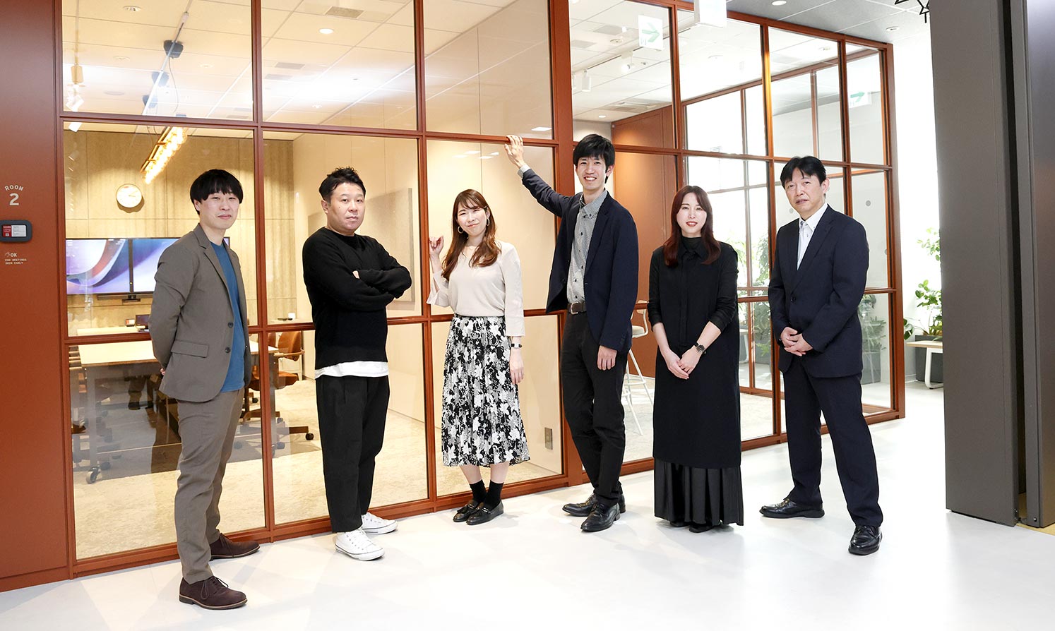 Project members lined up in front of a partition