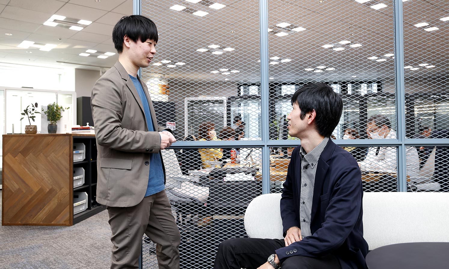 Ryo Eguchi and Masanori Tanaka talking in the office