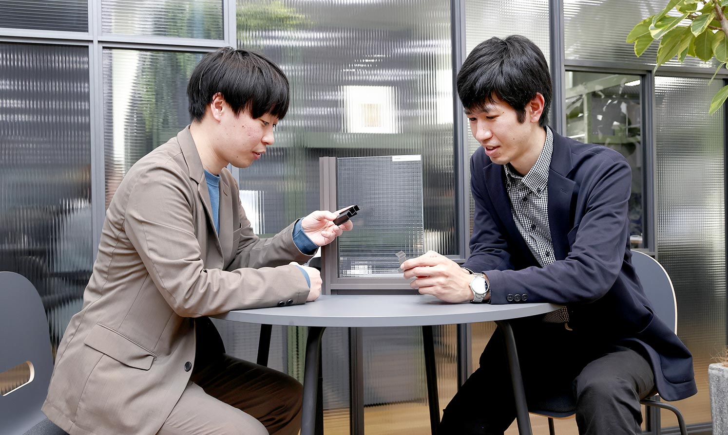 Ryo Eguchi and Masanori Tanaka talking in the office