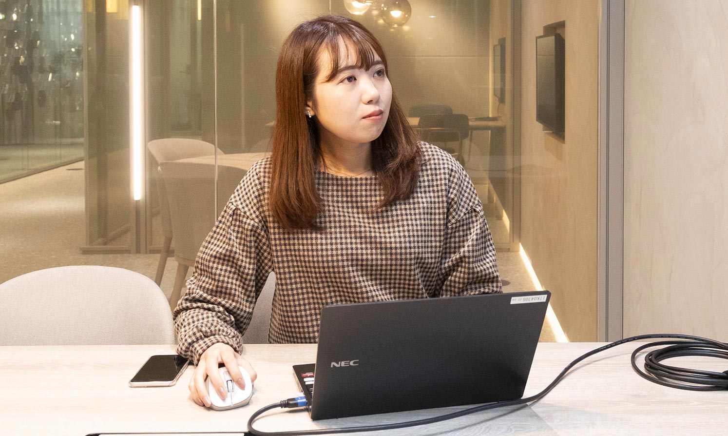 溝口 夏海 デスクでノートPCで業務をしている