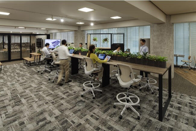 [Co-work space] A high-position workstation allows you to work while communicating with those around you.
